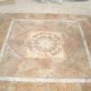 Floor medallion surrounded by diagonal tile carpet with travertine edging, 16x16 porcelain tile