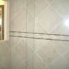 Close up of shower surround porcelain tile.  Diagonal pattern with a mosaic throughout.