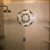 Porcelain tile tubsurround with 3 corner shelves and a medallion on back wall.