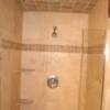 Nice travertine shower with coner shelves and ceiling tile.
