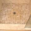 Travertine shower pan with noce 2 x 2 travertine on floor.