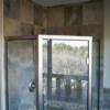 Corner shower surround with decorative mosaic through shower.