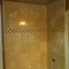 Simple but clean travertine tubsurround capped with a pencil liner on edge of tile.