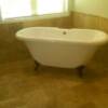 Master bathroom floor and waines coat surrounding a stand-alone tub.