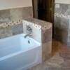 Nice master bathroom tubsurround with decorative piece throughout.
