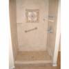 Porcelain tile jet shower system  with medallion on back wall.